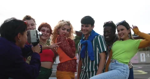 Young diverse people having fun with old vintage video camera outdoor Stock Footage 185509855