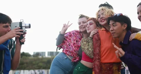 Young diverse people having fun with old vintage video camera outdoor Stock Footage 185510334