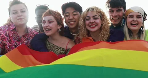 Young diverse people having fun holding LGBT rainbow flag outdoor Stock Footage 185515910