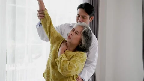 Young doctor doing physical therapy for elderly woman Stock Footage 153069170
