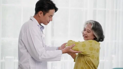Young doctor doing physical therapy to elbow senior woman Stock Footage 153069566