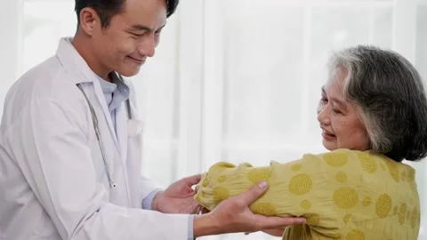 Young doctor doing physical therapy to elbow senior woman Stock Footage 153069574