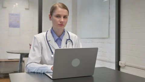 Young Doctor Looking at Camera while Using Laptop Video stock 309509173