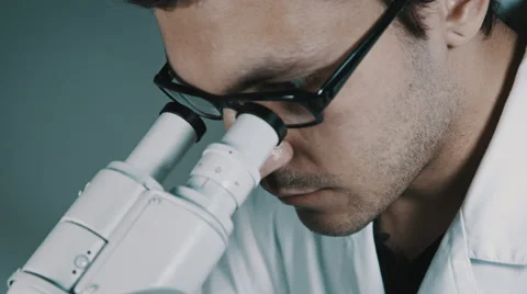 Young doctor  looking through the microscope Stock Footage 56361929