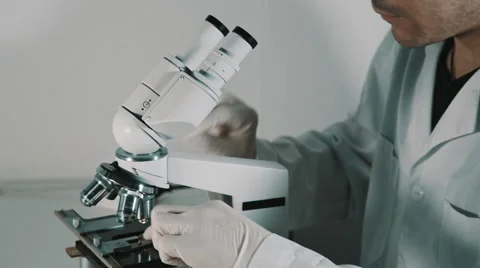 Young doctor  looking through the microscope Vídeo Stock 56365688
