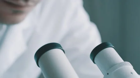 Young doctor  looking through the microscope Vídeos de archivo 59821601