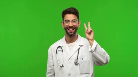 Young doctor man on chroma doing a gesture of victory Stock Footage 97707350