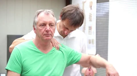 Young doctor performing shoulder examination Stock Footage 58632012