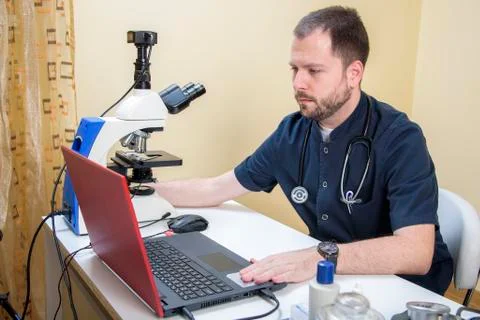 Young doctor researching on a microscope Stock Photos