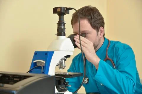 Young doctor researching on a microscope Stock Photos