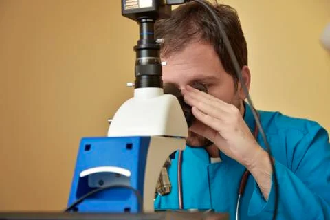 Young doctor researching on a microscope Stock Photos