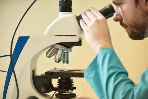 Young doctor researching on a microscope Stock Photos
