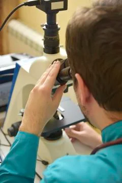 Young doctor researching on a microscope Stock Photos