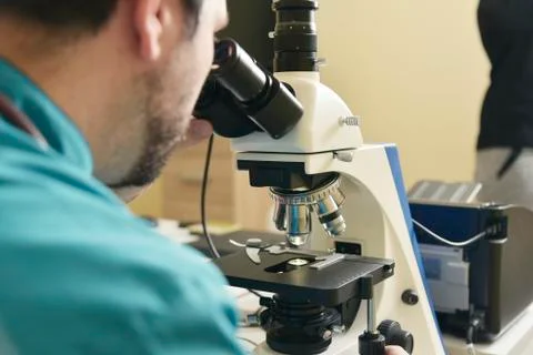 Young doctor researching on a microscope Stock Photos