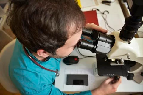 Young doctor researching on a microscope Stock Photos
