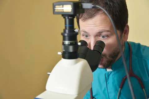 Young doctor researching on a microscope Stock Photos