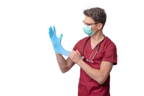 Young doctor in uniform getting ready to work putting on gloves isolated on a Stock Photos