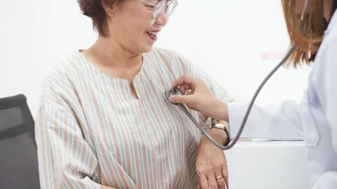 Young doctor using stethoscope to exam senior patient heart Stock Footage 130812881
