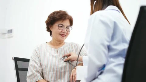 Young doctor using stethoscope to exam senior patient heart Stock Footage 130812923