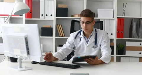 Young doctor working at computer in workplace. Stock Footage 91600160