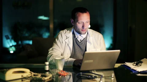 Young doctor working on laptop computer late at night HD Stock Footage 37593641