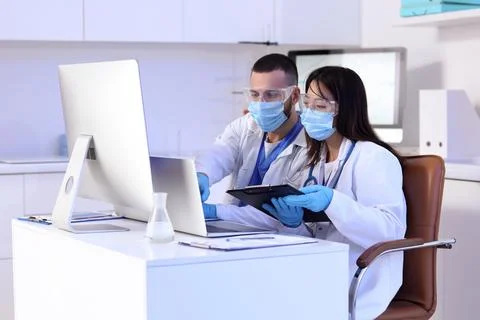 Young doctors analyzing scientific data at desk in laboratory Stock Photos
