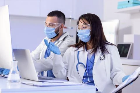 Young doctors analyzing scientific data at desk in laboratory Stock Photos