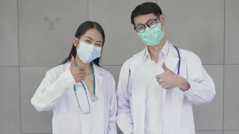 The young doctors are looking at the camera with their thumbs up. Stock Footage 146692291