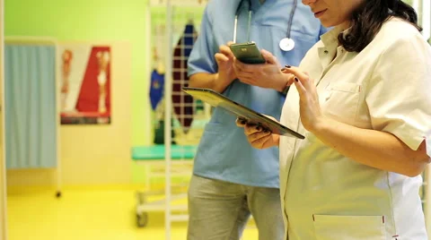 Young doctors comparing data on tablet and smartphone HD Stock Footage 45580744