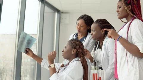 Young doctors examine an X-ray while standing at a table Stock Footage 148236398