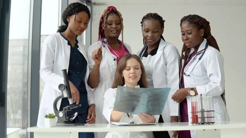 Young doctors examine an X-ray while standing at a table Stock Footage 148236552