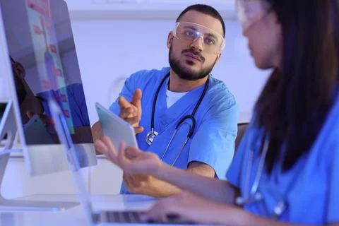 Young doctors with tablet computer analyzing scientific data at desk in labor Stock Photos