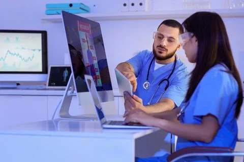 Young doctors with tablet computer analyzing scientific data at desk in labor Stock Photos