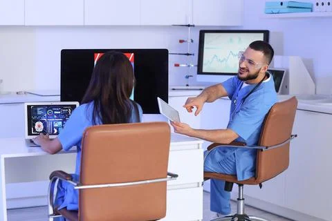 Young doctors with tablet computer analyzing scientific data at desk in labor Stock Photos