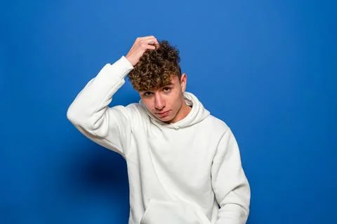 Young doubtful man thinking, scratching his head trying to find a solution, i Stock Photos