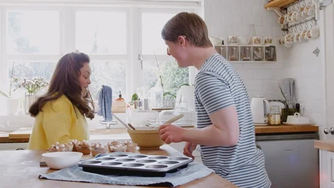 Young Downs Syndrome Couple Decorating Homemade Cupcakes And Dancing In Kitchen Stock Footage 114304113