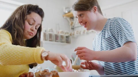 Young Downs Syndrome Couple Decorating Homemade Cupcakes With Marshmallows In Stock Footage 114304234