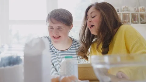 Young Downs Syndrome Couple Having Fun Baking In Kitchen At Home Stock Footage 114303306