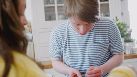 Young Downs Syndrome Couple Making Bunny Ears With Marshmallows As They Decorate Stock Footage 114304261