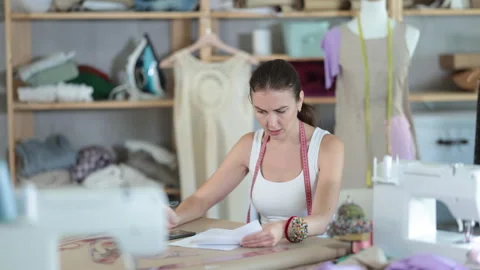 Young dressmaker is sorting out documents in the workshop. Employee of the Video stock 321338820