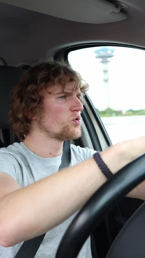 Young driver dances for fun while cruising through traffic in a moving car Stock Footage 342920168