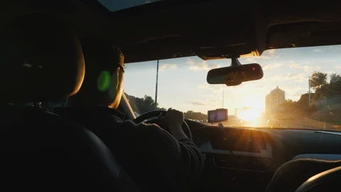 Young driver driving a car. Sunset rear view Stock Footage 101975477