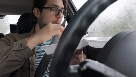 Young Driver Eats Take Away Food In His Car - Rainy Day Stock Footage 108857261