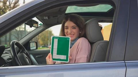 Young driver showing learner permit while sitting in car Stock Photos