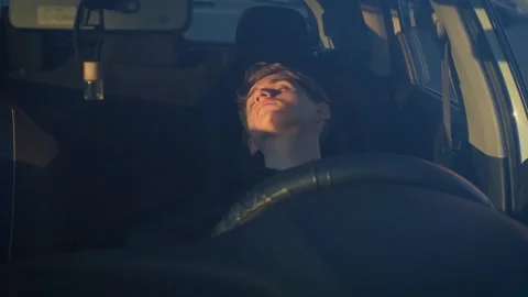 Young driver sleeping in a car early in the morning, view through the windshield Stock Footage 265703448