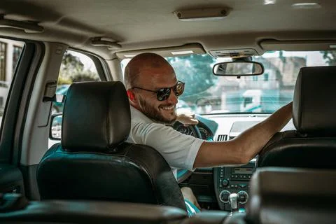 Young driver smiling and talking to other people in the car Foto stock