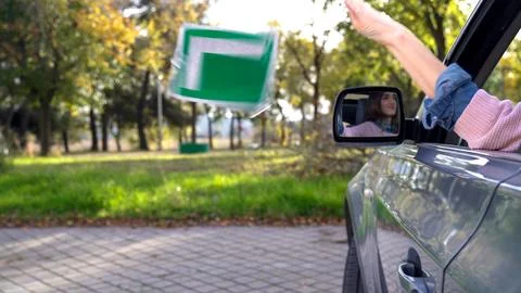 Young driver throwing l-plate away after passing driving test Stock Photos