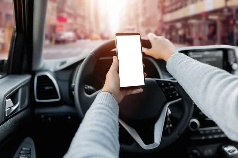 Young driver using smartphon in the car while driving or parking. Mockup of a Stock Photos