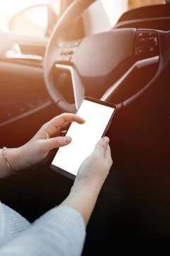 Young driver using smartphon in the car while driving or parking. Mockup of a Foto stock