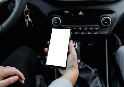 Young driver using smartphon in the car while driving or parking. Mockup of a Stock Photos